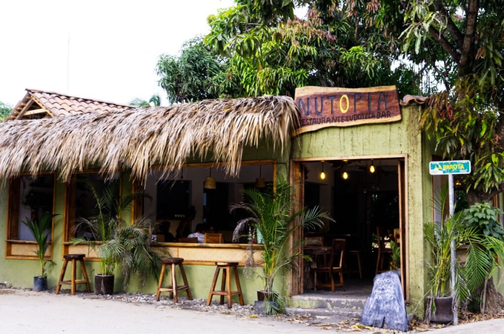 Three stools sit outside, under the palapa roof at Nutopia, a healthy restaurant in Mazunte.