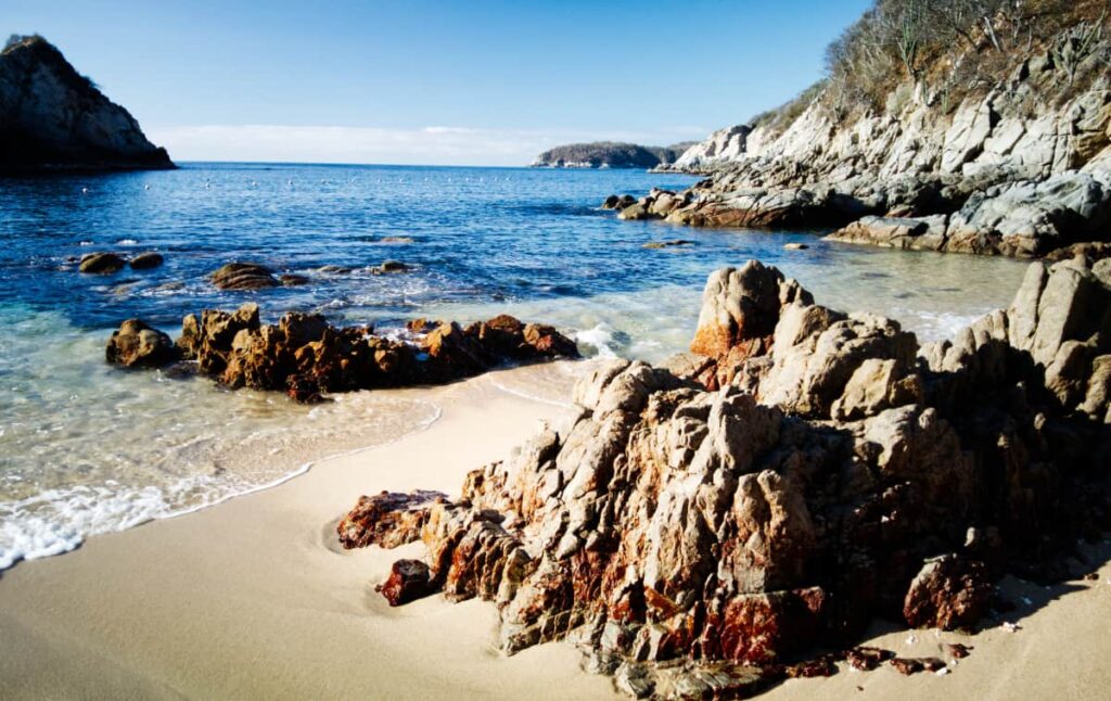 Small rock formations sit in the sand at Playa Violin in Huatulco, one of many beaches along the Oaxaca coast.