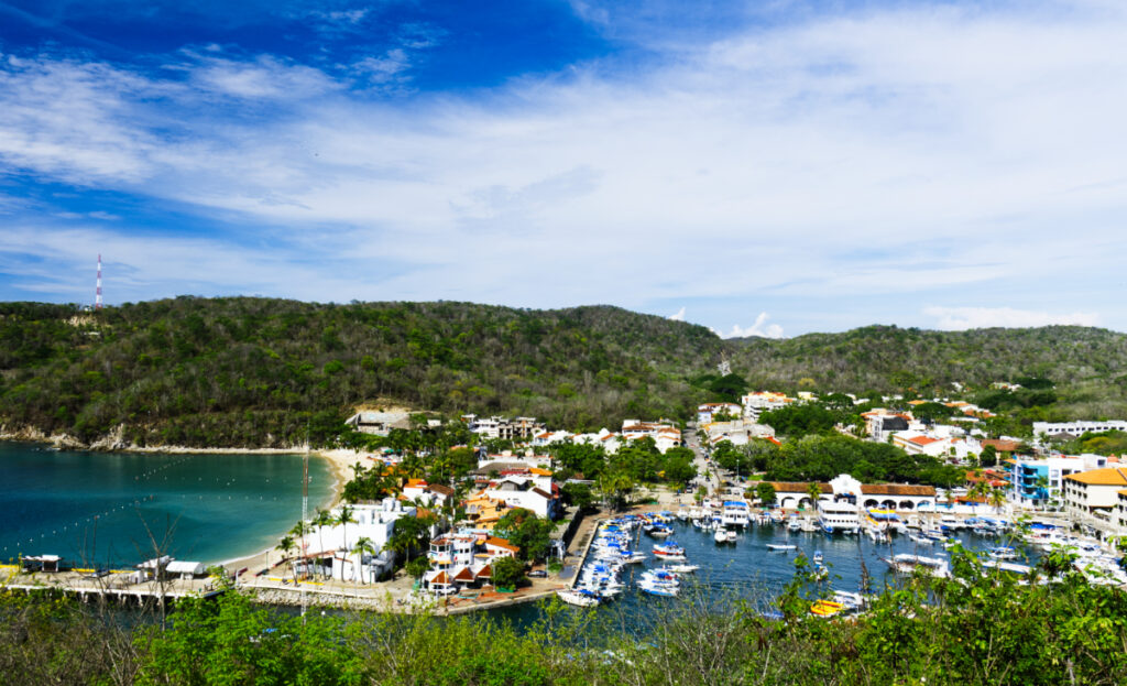 A overview angle of the marina which is full of boats. Just past the buildings on the left is Santa Cruz Bay, one of the most popular beaches in Huatulco, Mexico.