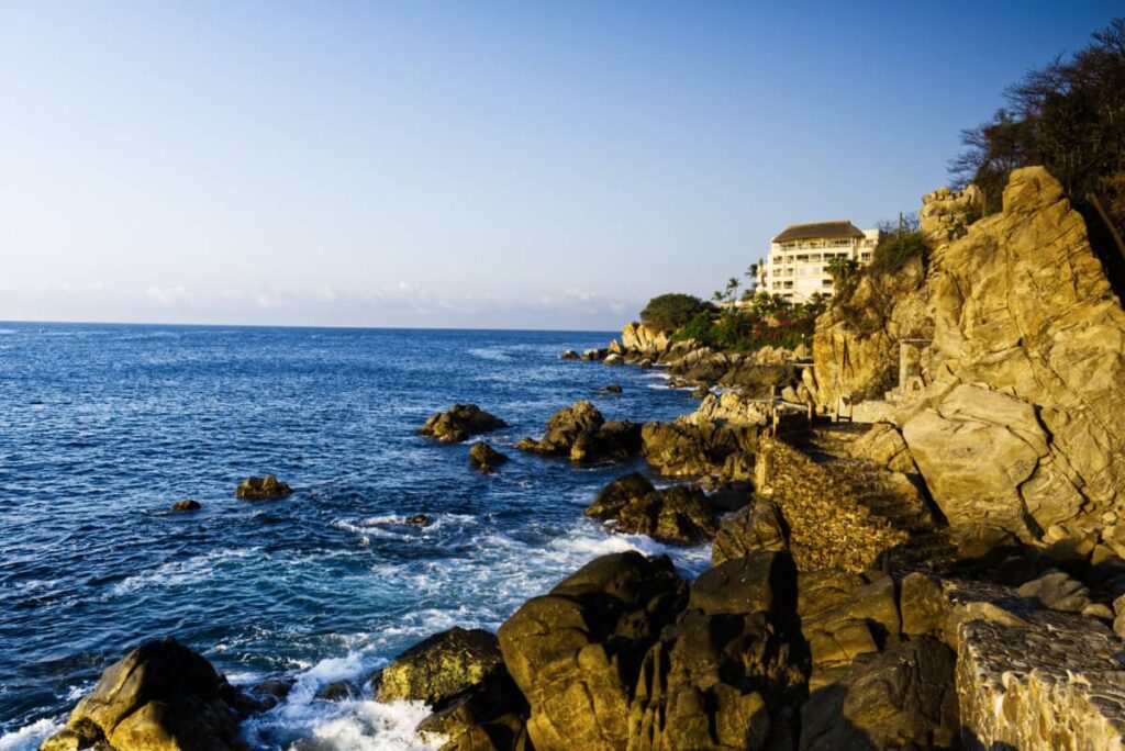 Morning light illuminates the large rocks next to the ocean along this hike in Puerto Escondido, Mexico.