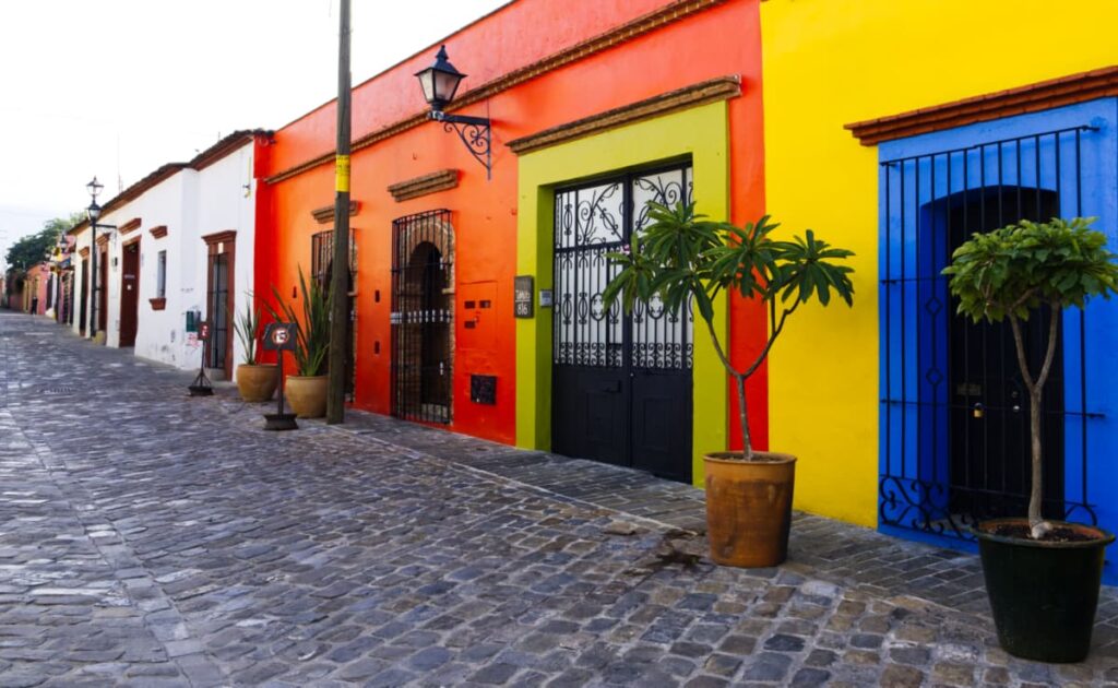 Colorful buildings line the stone paved street in Xochimilco, Oaxaca.