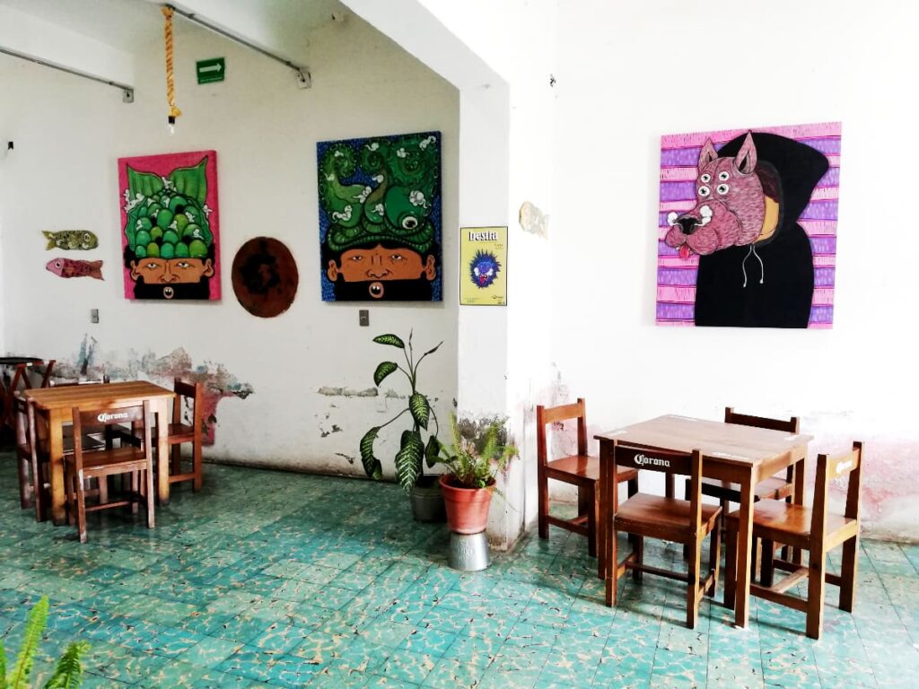 Colorful art hangs on the walls at El Quinque Restaurant which has some of the best burgers in Oaxaca.