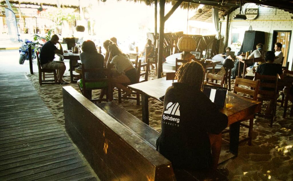 Several people work from the wooden tables at the restaurant in Selina Puerto Escondido, an alternative coworking space in Zicatela.