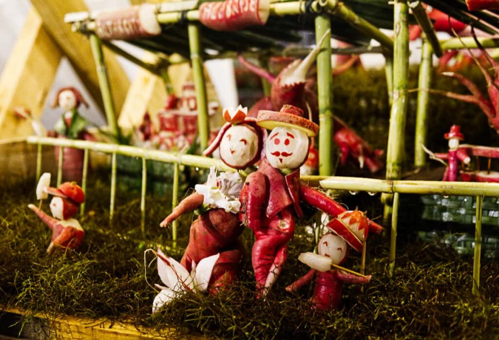 At the night of the radishes in Oaxaca, a mother, father, and two children are made from carved radishes. The children each have a paleta, or popsicle in their hand. The natural twisted growth of a radish was used for legs in the father and it's marvelous.