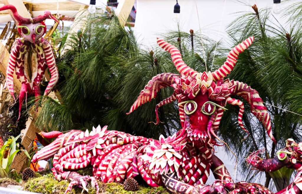 At Noche de Rabanos Oaxaca, a giant mythical figure is depicted in carved radishes. The figure's decoration are Zapotec patterns, especially along the body, legs, and multiple horns.