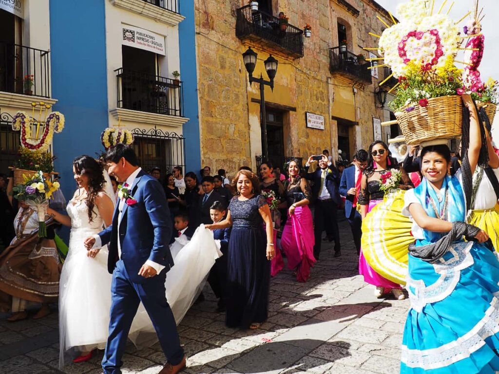 One of the fun things to do in Oaxaca is to attend a wedding parade, such as this one where the bride and groom lead the parade which includes women in traditional dress, holding a basket of flowers on their heads.