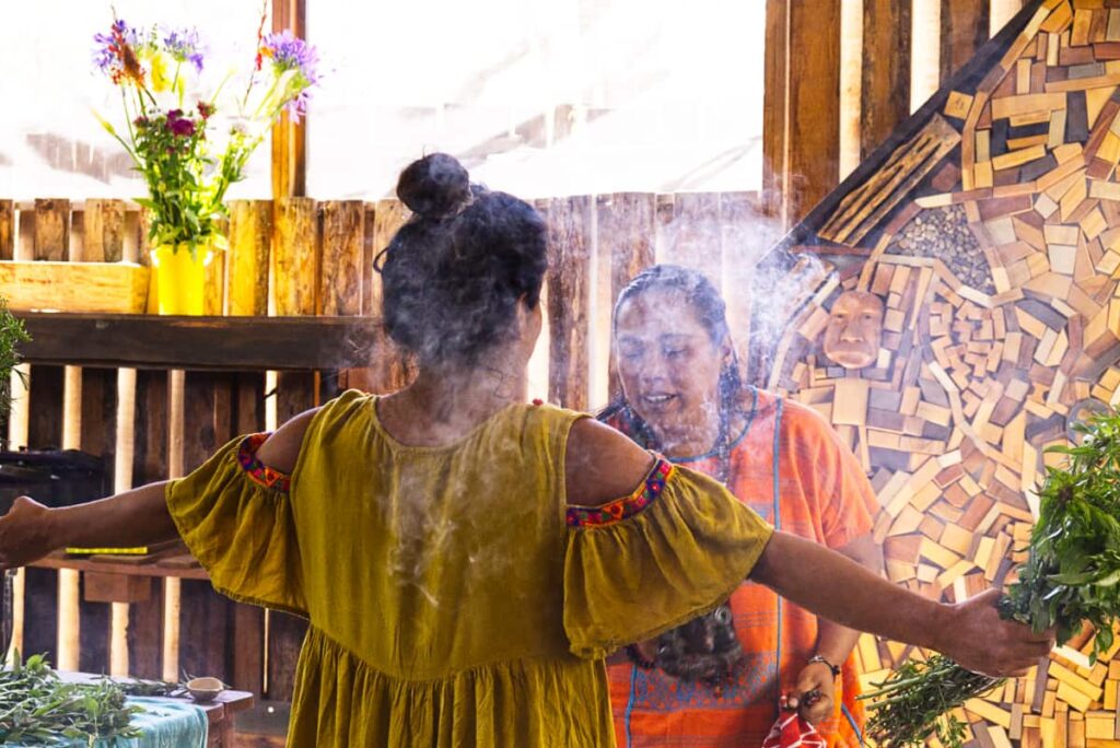 Raquel burns copal and passes it near the body of a woman to cleanse her spirit at the start the temazcal ceremony in Oaxaca.