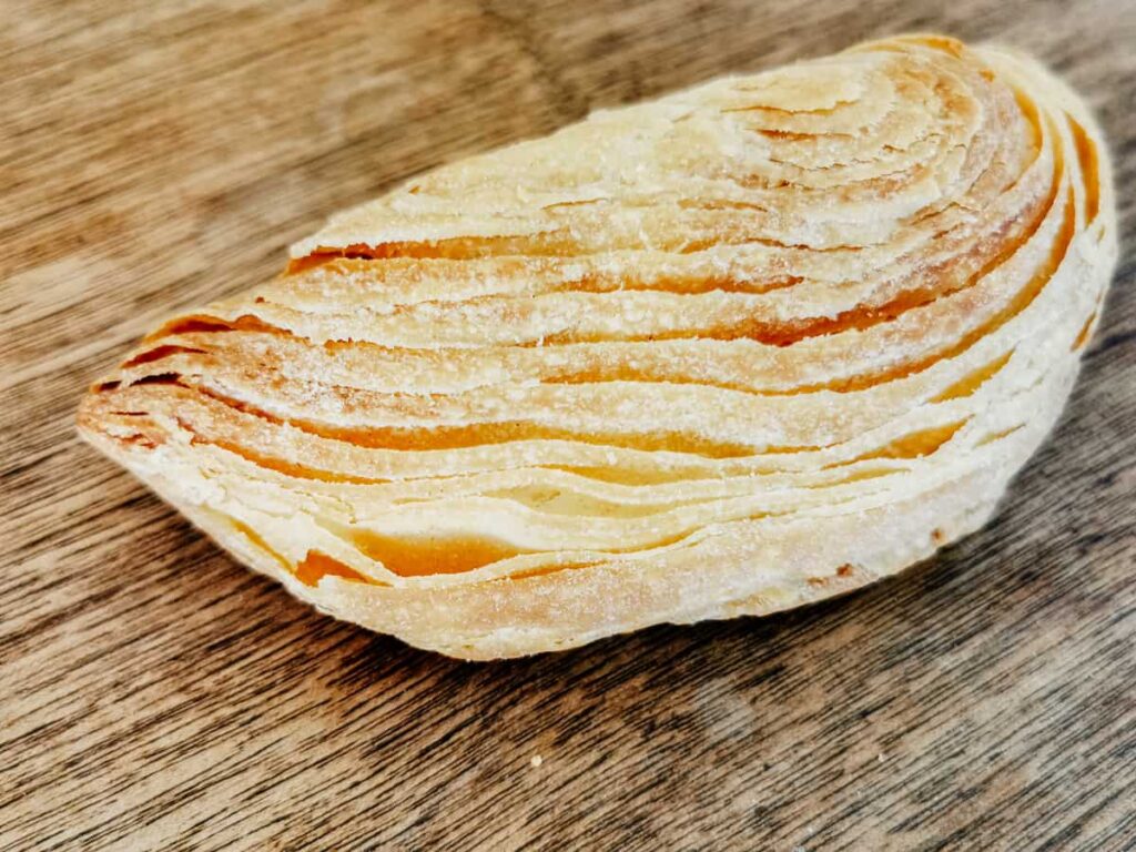 Up close view of the layers of flaky dough of a coconut empanada, a traditional Oaxacan dessert.