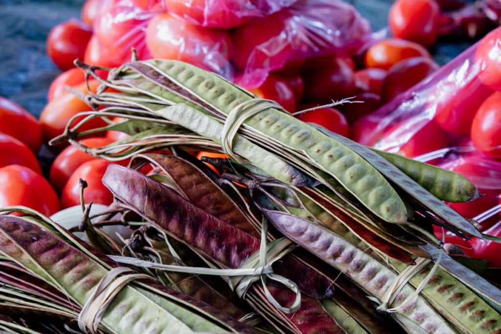 Bundles of green guaje pods sit on a table at a market in Oaxaca. This is a traditional snack or food in Oaxaca, and for which the city is named.