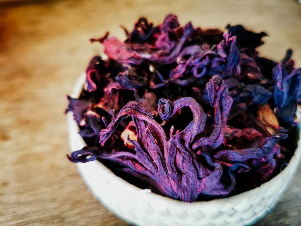 A bowl of dried purple hibiscus flowers, a modern ingredient in Oaxacan cooking, sit in a woven basket.
