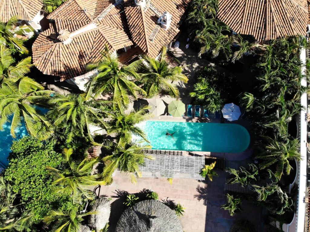 An aerial view of the pool at Hotel Santa Fe surrounded by palm trees and hotel property.