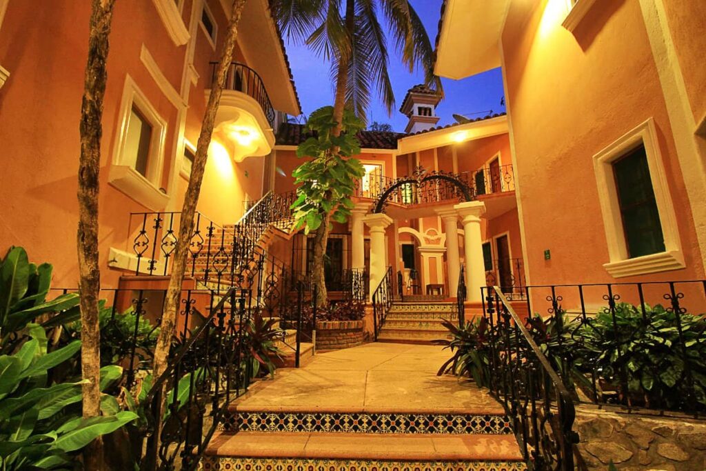 An exterior space at Hotel Santa Fe with tiled stairs, black steel railings and lush green spaces.