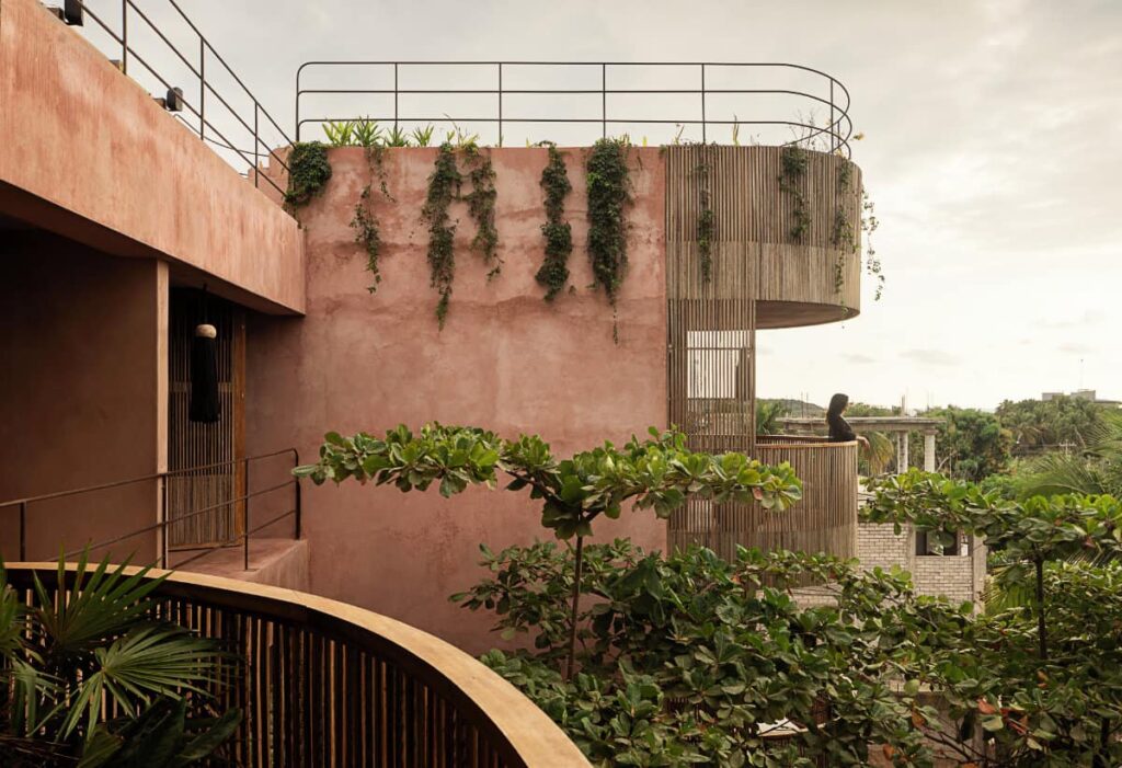 A view of the balcony at Xique boutique hotel with wooden railings and surrounded by lush greenery.