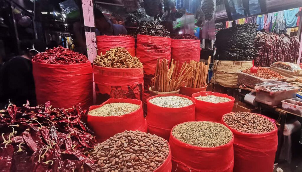 Red sacks at Central de Abastos Oaxaca are filled to the brim with dried beans, chiles, and other items for sale.