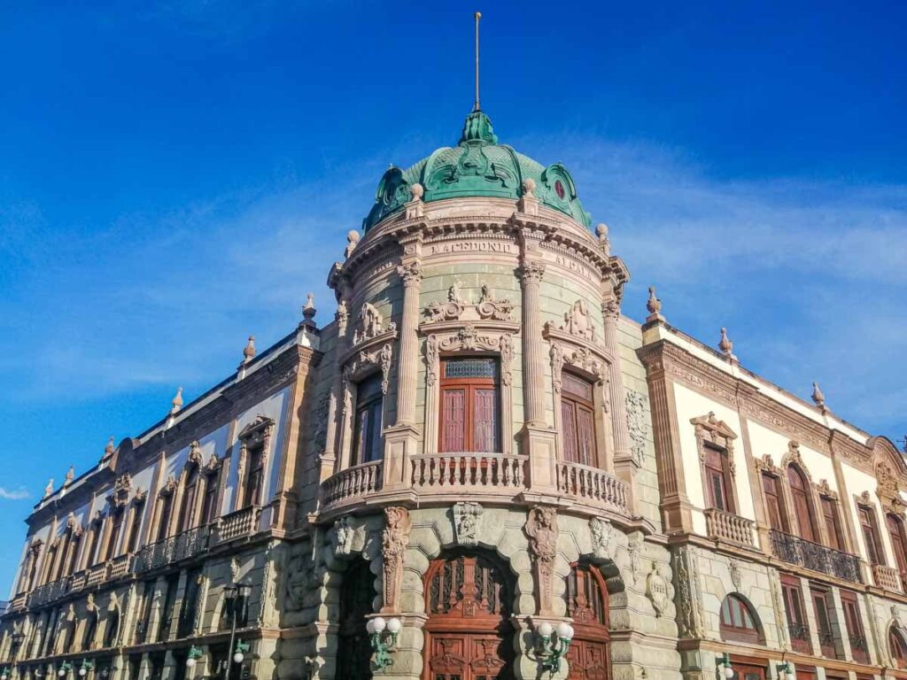 The Macedonio Theater in Oaxaca Centro features the green stone the city is known for and a large green metal dome.