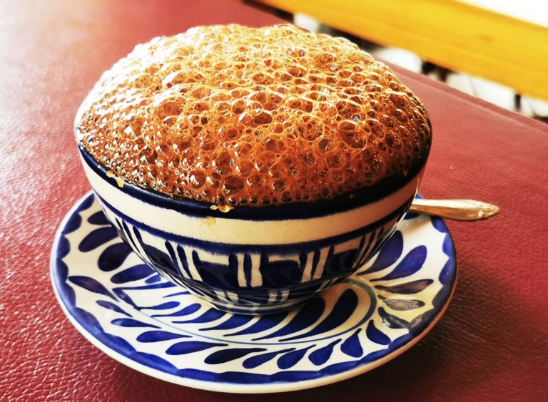 In the Sierra Norte region of Oaxaca, chocolate colored foam expands over the top of a blue and white porcelain cup of chocolate de agua.